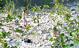 Guardone riprende due ragazze in topless in riva al fiume
